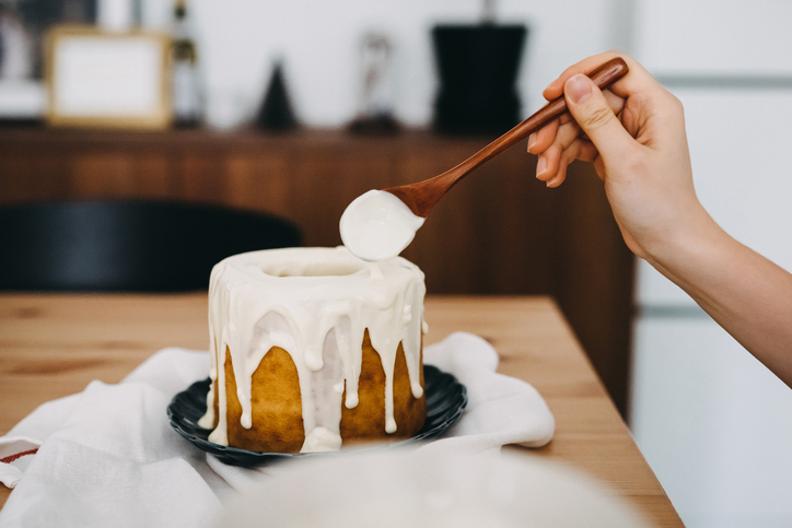 White chocolate frosting dripping onto a cake.