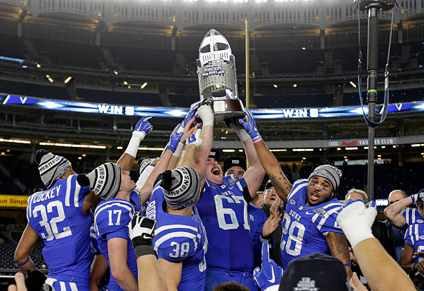 Lucas Patrick of the Duke Blue Devils holds up a trophy after defeated the Indiana Hoosiers in the New Era Pinstripe Bowl at Yankee Stadium on...