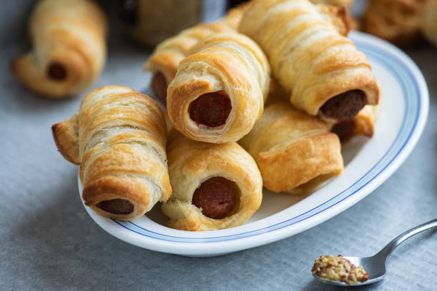 pigs in a blanket - mini sausage roll on a plate. - roll pretzel dough stock pictures, royalty-free photos & images