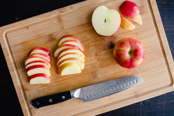 sliced honeycrisp apples on a bamboo cutting board - apple slices stock pictures, royalty-free photos & images