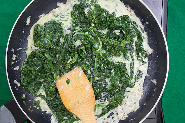 spinach cooking in pan - cooking spinach stock pictures, royalty-free photos & images