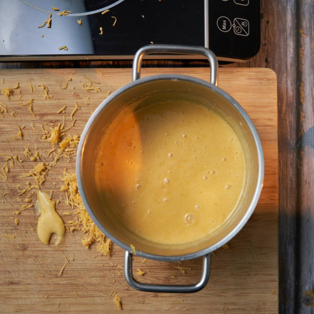 cheddar sauce - making beer cheese sauce stock pictures, royalty-free photos & images