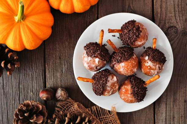 autumn acorn shaped pumpkin spice donut holes. table scene over rustic wood. - acorn donut holes stock pictures, royalty-free photos & images