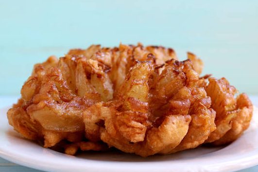 fried onion with breading in a plate. - making fried blooming onion stock pictures, royalty-free photos & images