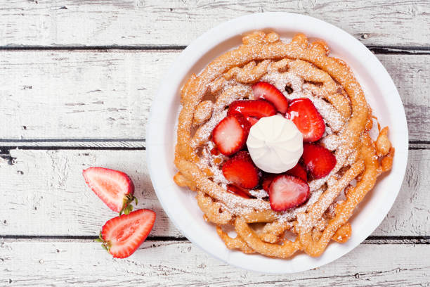 strawberry funnel cake overhead view on a white wood background - funnel cake stock pictures, royalty-free photos & images