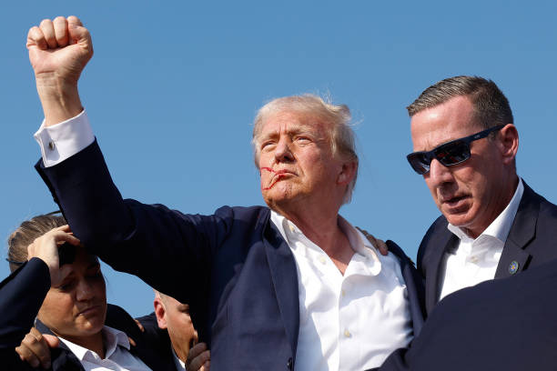 Republican presidential candidate former President Donald Trump pumps his fist as he is rushed offstage during a rally on July 13, 2024 in Butler,...