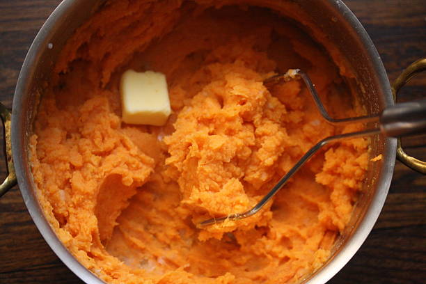 sweet potato mash with a knob of butter - making sweet potato casserole stock pictures, royalty-free photos & images