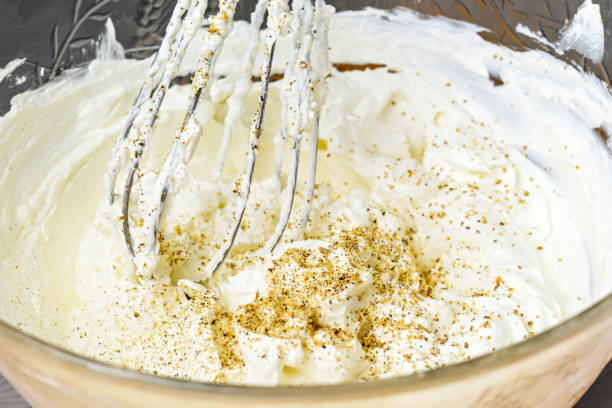 whisk mixes a hearty dip of goat cream cheese with ground nuts and pepper in a glass bowl, selected focus - whipping feta stock pictures, royalty-free photos & images