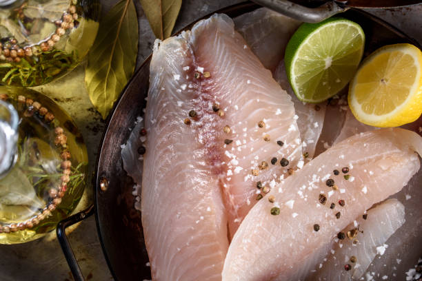 raw tilapia fillet with spices - tilapia fillet stock pictures, royalty-free photos & images