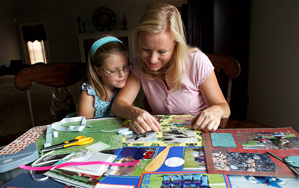 mother and daughter making a scrapbook photo album - scrap booking stock pictures, royalty-free photos & images