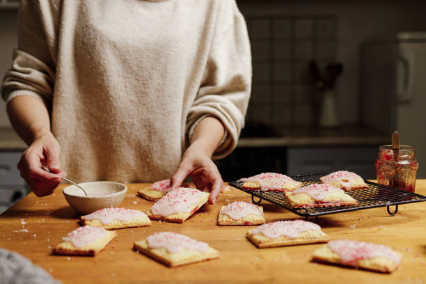 female making tasty toaster pastry at home - homemade pop tarts stock pictures, royalty-free photos & images