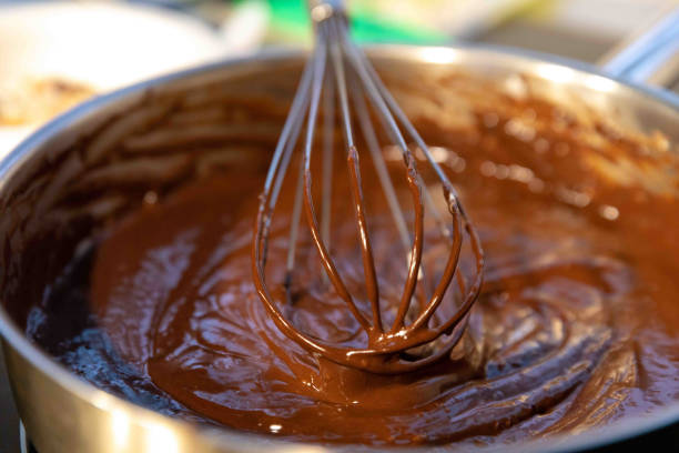 close up view of brownie mix being prepared with whisk in restaurant kitchen. - making chocolate cookies stock pictures, royalty-free photos & images