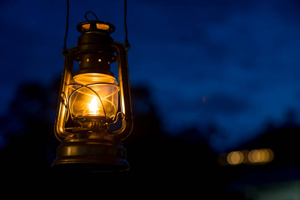 oil lamp lighting up the darkness or burning kerosene lamp background, camping light concept - railroad lanternn dark stock pictures, royalty-free photos & images